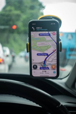 Arabanın içinde Waze navigasyon uygulaması olan bir iPhone X. Waze iyi seyrüsefer için popülerlik kazandı.