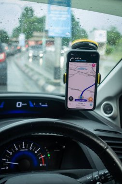 Arabanın içinde Waze navigasyon uygulaması olan bir iPhone X. Waze iyi seyrüsefer için popülerlik kazandı.