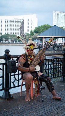 Sarawakian Man Sape çalıyor, geleneksel Sarawak Müzik Enstrümanı