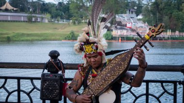 Sarawakian Man Sape çalıyor, geleneksel Sarawak Müzik Enstrümanı