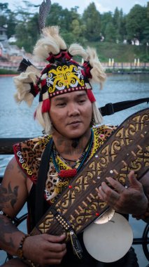 Sarawakian Man Sape çalıyor, geleneksel Sarawak Müzik Enstrümanı