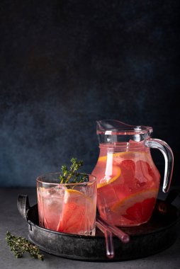 Votka ve buzlu greyfurt suyu karanlık bir masada cam bir sürahide.