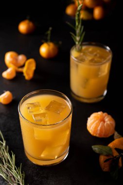 Taze sıkılmış mandalina suyu. Koyu bir arka planda buzlu.