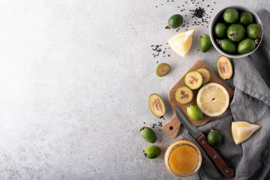 Beyaz bir masada limon ve bal ile olgun feijoa.