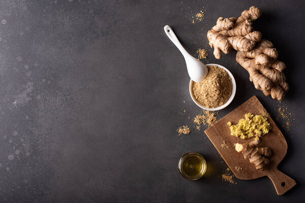 ginger root and ground dried ginger on a dark background, top view