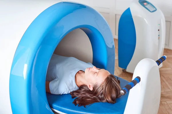 Wave therapy. The magnetic field, rehabilitation. A woman uses a magnetic therapy system to treat and prevent diseases. Woman and doctor.