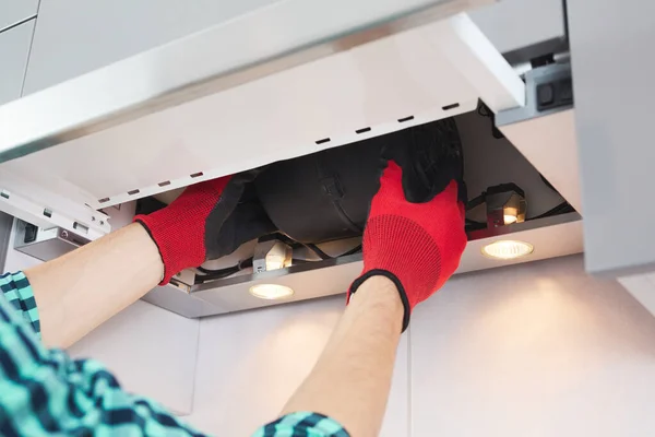 Elektrikçinin erkek eli fırın kabininde sorun var. Kaputu tamir ediyor..