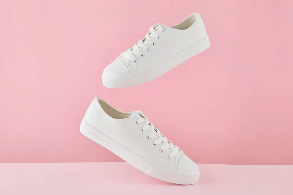 Coppia di scarpe da ginnastica bianche alla moda, scarpe sportive running su sfondo rosa pastello. — Foto Stock
