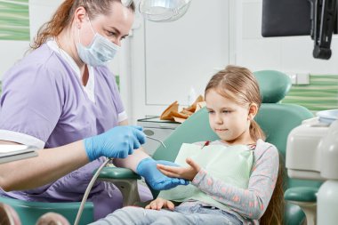 Çocuk dişçiye. Ameliyat sırasında diş hekiminde çalışan bir çocuk. Diş sağlığı kliniğinde küçük bir hasta ziyaret uzmanı..