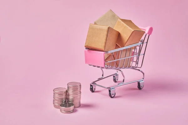 带有粉红背景包装盒的购物车 购物和送货的概念 — 图库照片