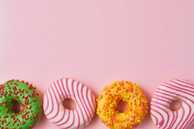 Moda pembe arka planda çok renkli jöleli donut. Donut geleneksel tatlı hamur işidir. Tatlı çörekler..