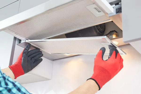 Elektrikçinin erkek eli fırın kabininde sorun var. Kaputu tamir ediyor..