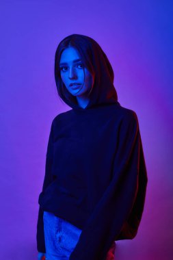 Stüdyoda, gece kulübünde poz veren neont ışıkları içinde model bir kadın. Moda makyajlı güzel seksi kızın portresi..