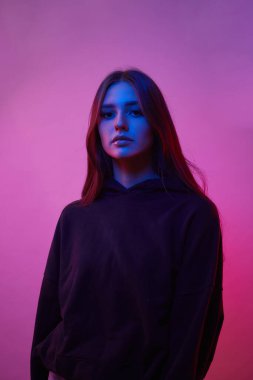 Stüdyoda, gece kulübünde poz veren neont ışıkları içinde model bir kadın. Moda makyajlı güzel seksi kızın portresi..