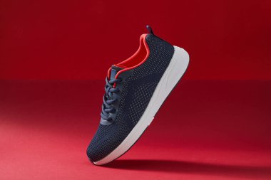 Renkli spor ayakkabılar ya da kırmızı arka planda ayakkabılar. Spor ve spor için mavi spor ayakkabıları çalıştırmak.