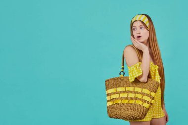 Mavi arka planda komik duygusal genç kız portresi. Sarı elbiseli bayanın stüdyoda poz vermesine çok şaşırdım..