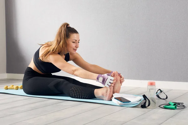 Woman In Fitness Wear Doing Exercise At Home. Time for yoga. healthy girl doing exercises while resting at home. Fitness, stay home concept.