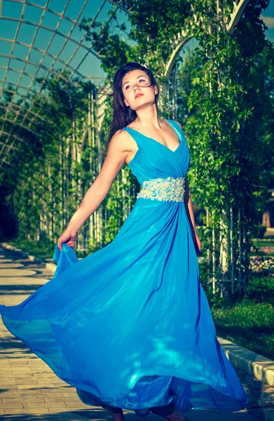 Beautiful woman dancing barefoot in a long blue dress — Stock Photo, Image
