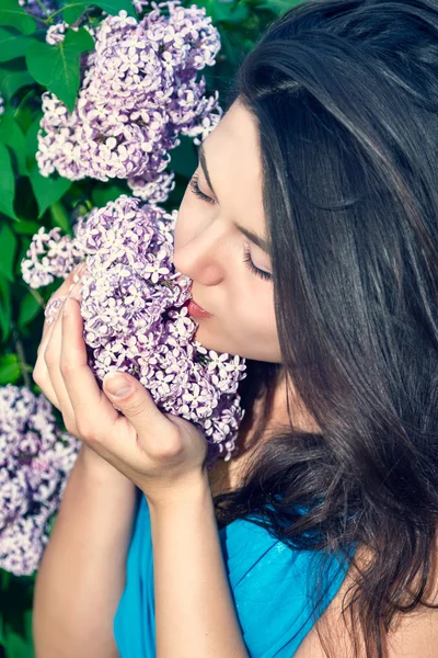 Beautiful woman enjoying the smell of flowers — Stock Photo, Image