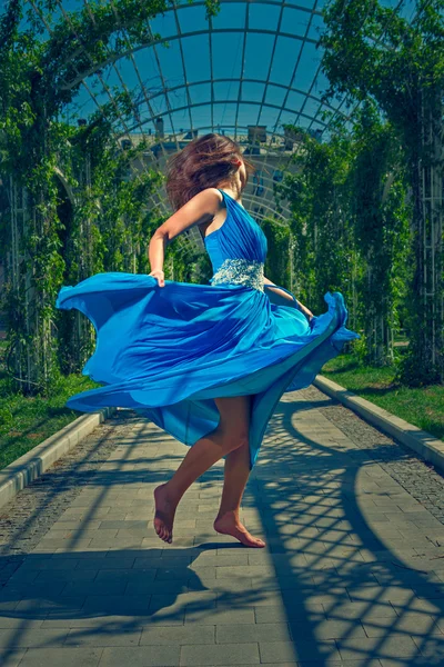 Mooie vrouw blote voeten dansen in een lange blauwe jurk Stockfoto