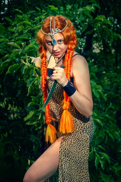 Beautiful woman in a leopard print dress with a knife in his han — Stock Photo, Image