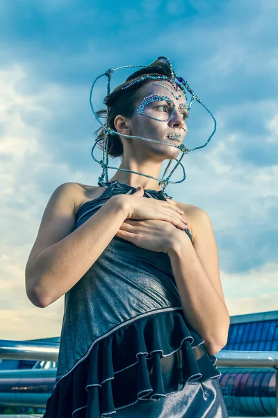 Belle femme dans une robe argentée avec des cristaux sur le visage — Photo