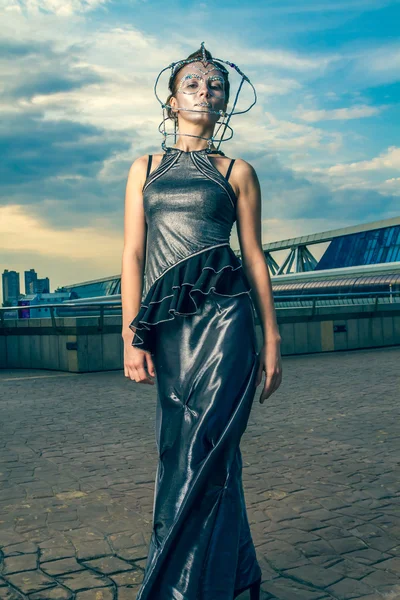 Hermosa mujer en un vestido de plata con cristales en la cara Imagen De Stock