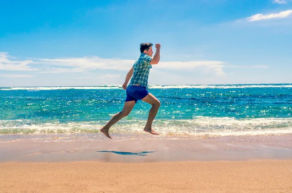 Homem correndo na praia tropical — Fotografia de Stock