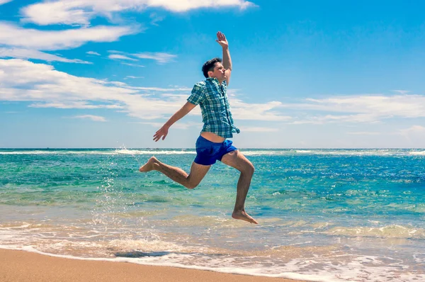 Человек бежит по тропическому пляжу — стоковое фото