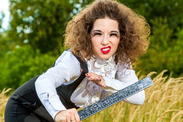 Sexy young teacher with a ruler posing outdoors — Stock Photo, Image