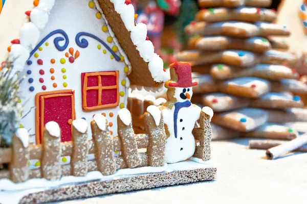 gingerbread house and gingerbread christmas decoration in the snow