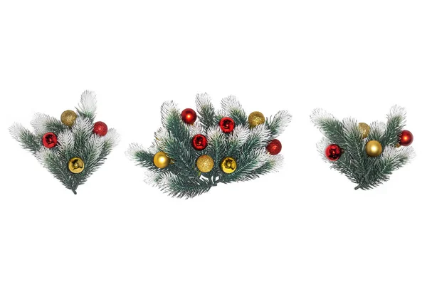 크리스마스 때 눈이 쌓여 있고 흰 배경에 황금빛 공이 박혀 있는 전나무 가지 장식 — 스톡 사진