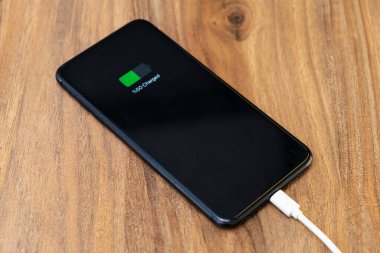 Akıllı telefon şarjı, hızlı kablo şarj konseptinde yarım şarj pili gösteriyor.