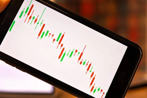 Close up n kézben tartó okostelefon gyertyatartó grafikon a kereskedelmi tőzsdén befektetési crypto valuta — Stock Fotó