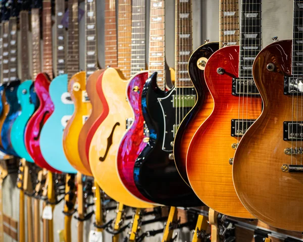 Bir müzik enstrümanları dükkanında akustik ve elektro gitar satışı farklı renktedir.