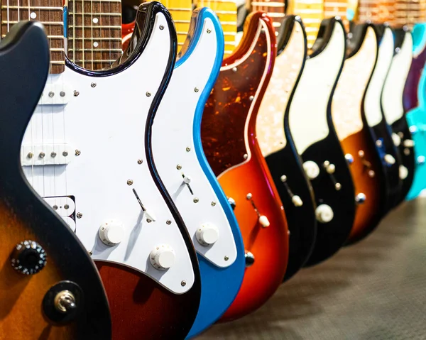 Fila de guitarras elétricas cor diferente em uma loja de instrumentos de música — Fotografia de Stock