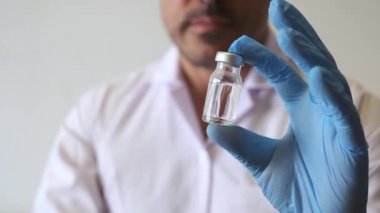 Doktor aşısı kavanozu ampul beyaz bornoz ve eldiven.