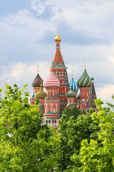 St. Basil's Cathedral, trees in the foreground in blurred focus. Russia Moscow May 2021