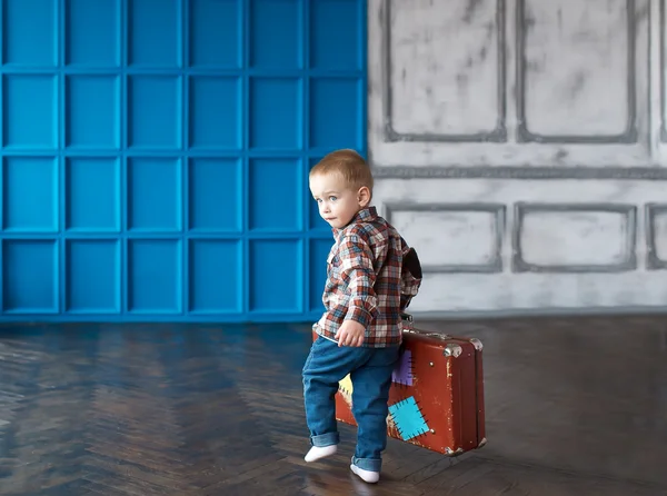 The boy with a suitcase in the big room. — Stock Photo, Image