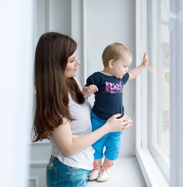 Mother and kid are by window. — Stock Photo, Image