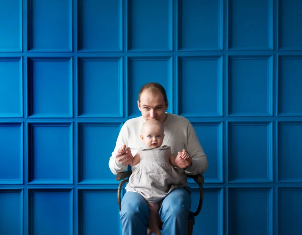 The father with the little daughter sit on a chair. — Stock Photo, Image