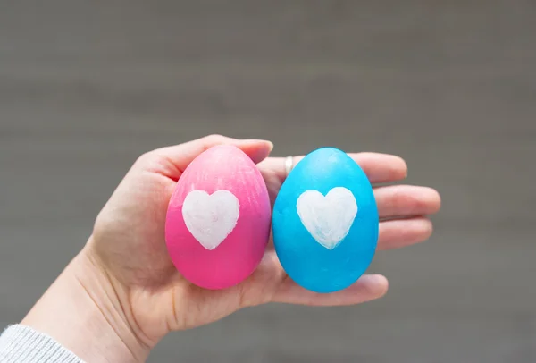 Ovos de Páscoa com corações em uma mão na pessoa . — Fotografia de Stock