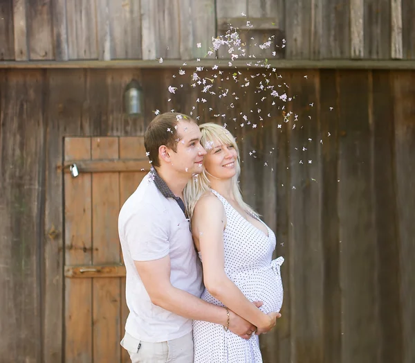 The husband embraces the pregnant wife.