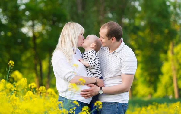 Familia se odihneşte pe câmpul de viol . — Fotografie, imagine de stoc