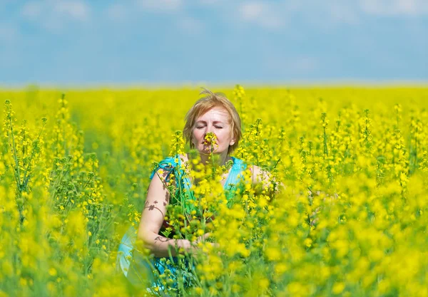 A mulher gosta do aroma de flores amarelas . — Fotografia de Stock