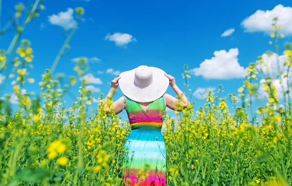 La mujer con sombrero camina en el campo de la violación . — Foto de Stock