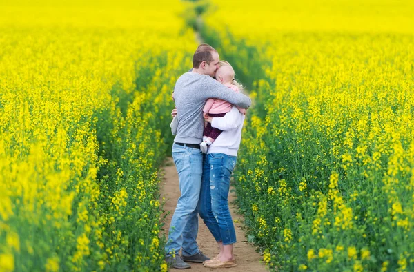 The family has a rest on the rape field. — Stock Photo, Image