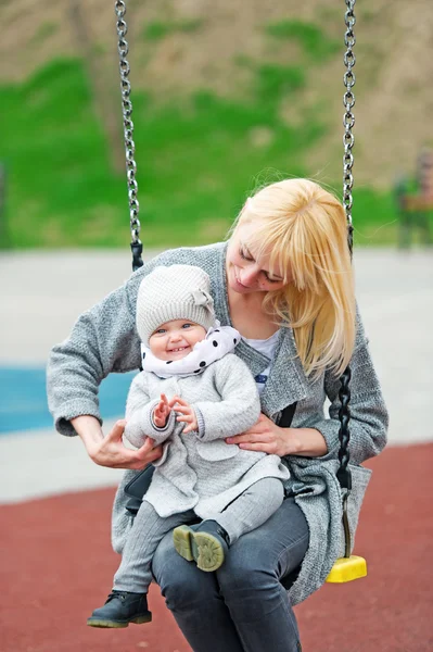 Mother and the little daughter shake on a swing. — Stock Photo, Image