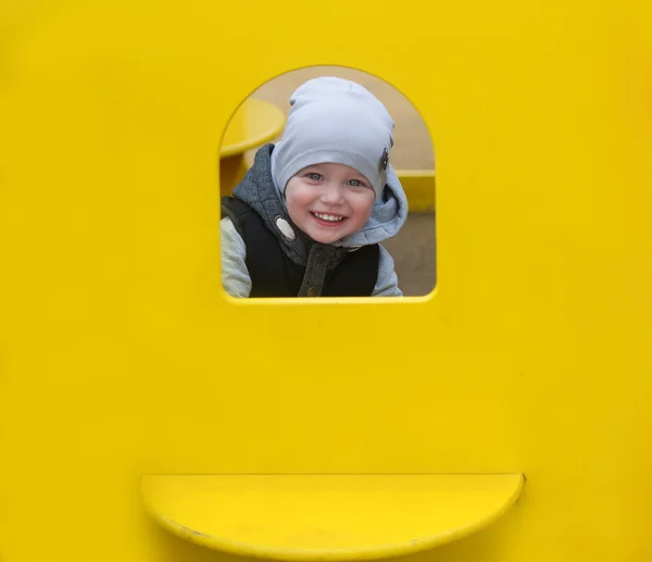 Хлопчик дивиться з жовтого вікна . — стокове фото