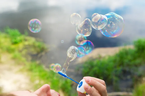 Burbujas de jabón vuelan contra un hermoso paisaje . —  Fotos de Stock